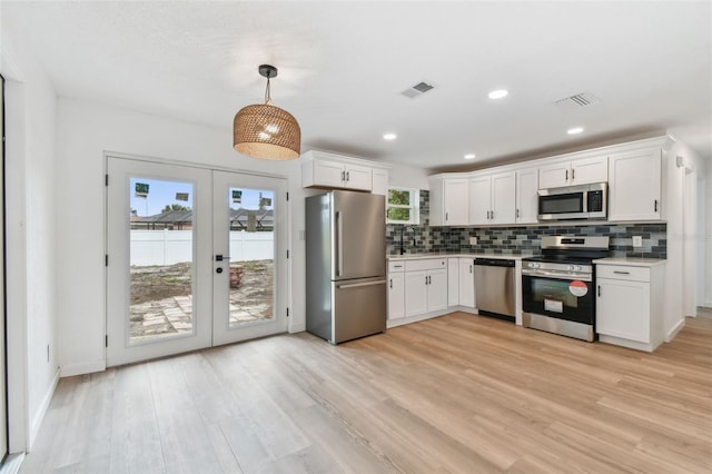 kitchen featuring visible vents, appliances with stainless steel finishes, light countertops, french doors, and backsplash