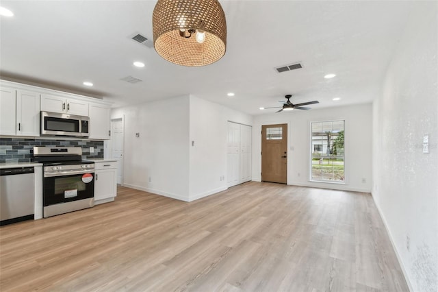 kitchen featuring stainless steel appliances, light wood-type flooring, backsplash, and visible vents