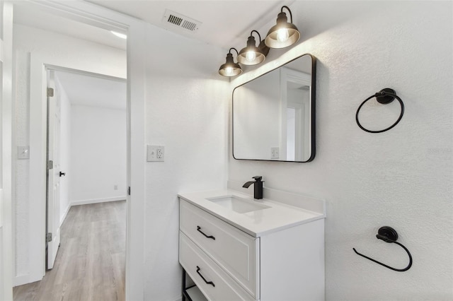 bathroom featuring visible vents, vanity, and wood finished floors