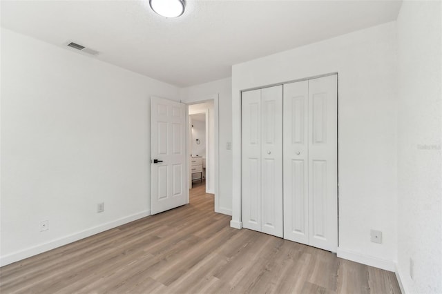 unfurnished bedroom with light wood-style floors, baseboards, and visible vents