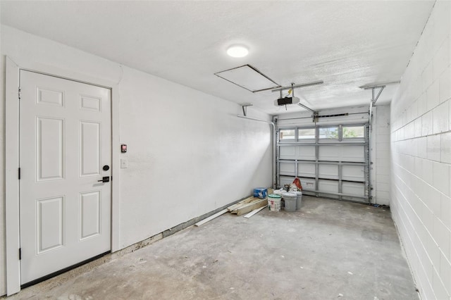 garage with concrete block wall and a garage door opener