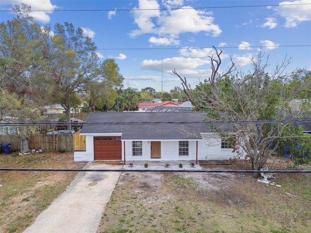 view of front of property with concrete driveway, an attached garage, and fence