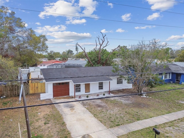 view of front of home featuring driveway, an attached garage, fence, and roof with shingles