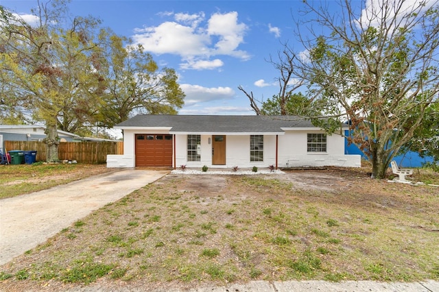 single story home with concrete driveway, fence, and an attached garage