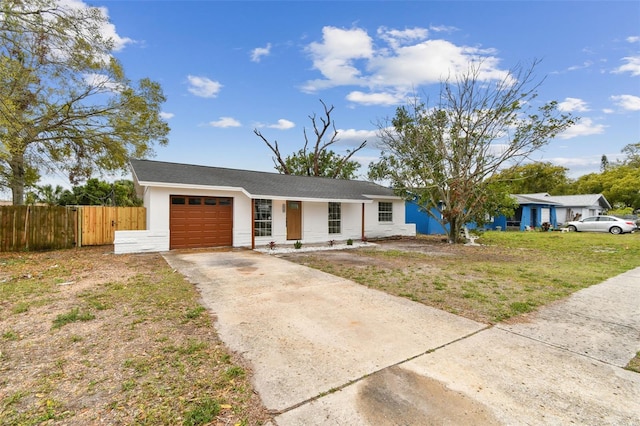 view of front of house with an attached garage, fence, concrete driveway, and stucco siding