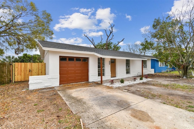 single story home with a garage, a shingled roof, fence, driveway, and stucco siding