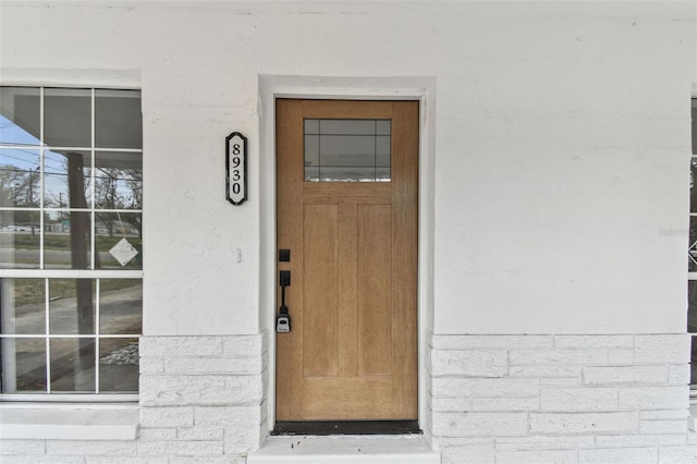 property entrance with stucco siding