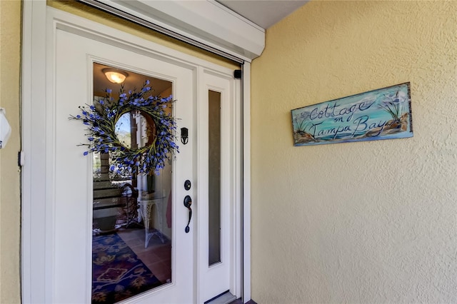 entrance to property featuring stucco siding