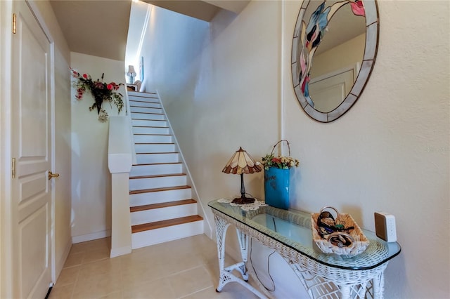 stairway featuring baseboards and tile patterned flooring