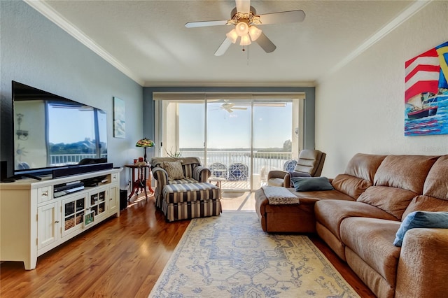 living area with ceiling fan, wood finished floors, and ornamental molding