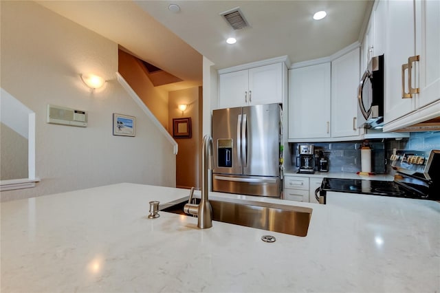 kitchen featuring white cabinetry, decorative backsplash, visible vents, and stainless steel appliances