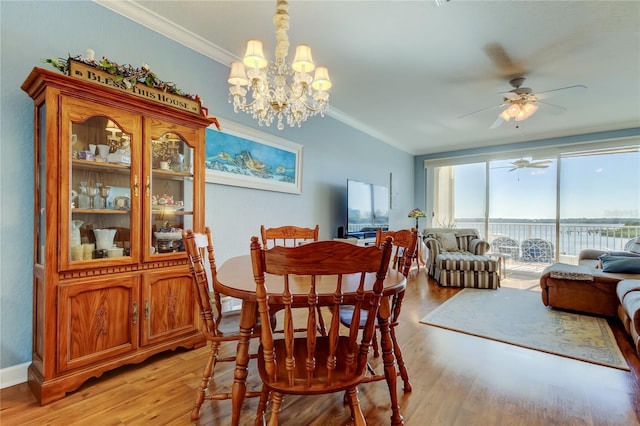 dining space with expansive windows, light wood-style flooring, crown molding, and ceiling fan with notable chandelier