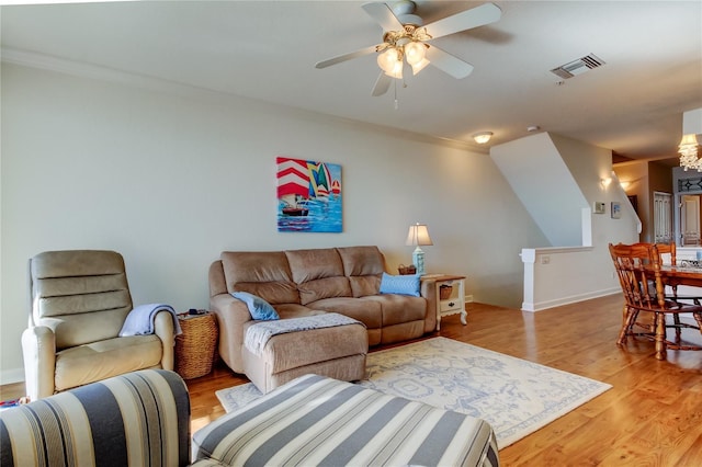 living area with light wood finished floors, visible vents, baseboards, and ceiling fan