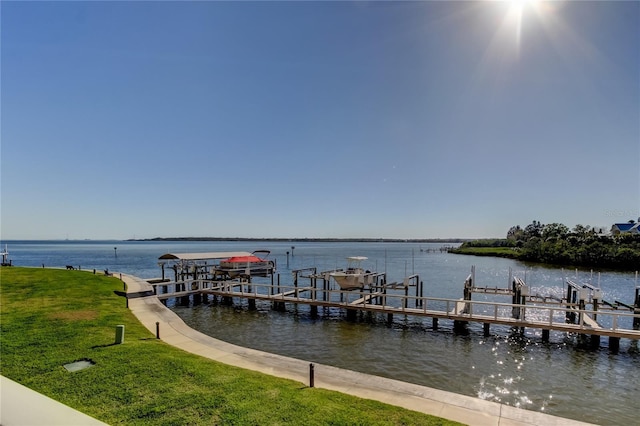 dock area with a yard, a water view, and boat lift