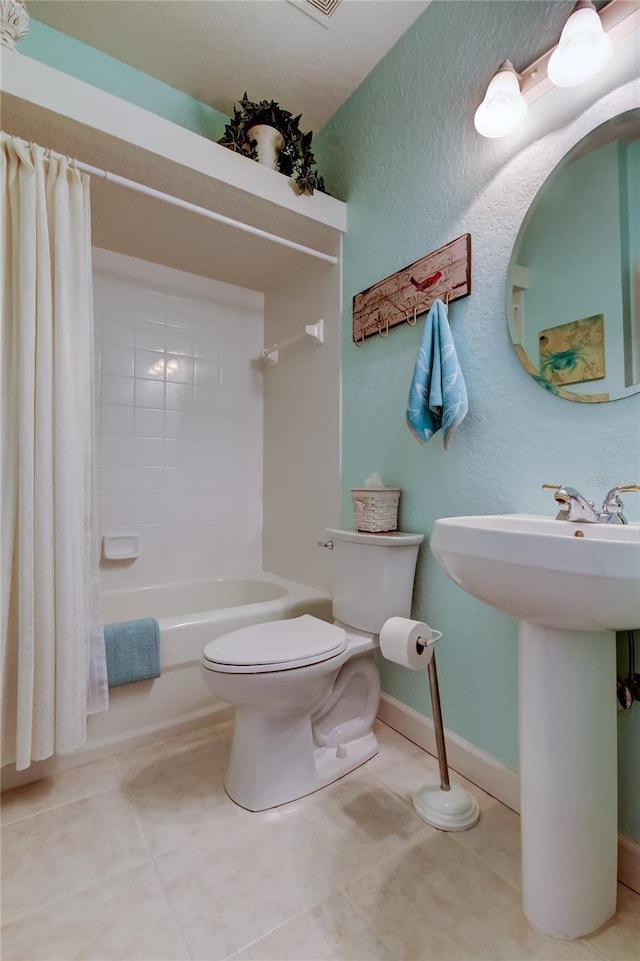 full bath featuring baseboards, shower / bath combo with shower curtain, toilet, and tile patterned flooring