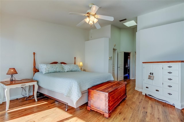 bedroom with light wood finished floors, visible vents, a skylight, and ceiling fan