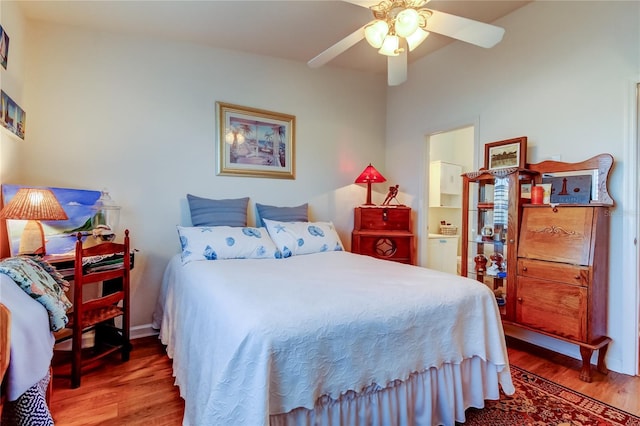 bedroom featuring ceiling fan, ensuite bath, and wood finished floors