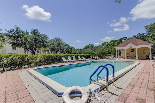 community pool with a patio and fence