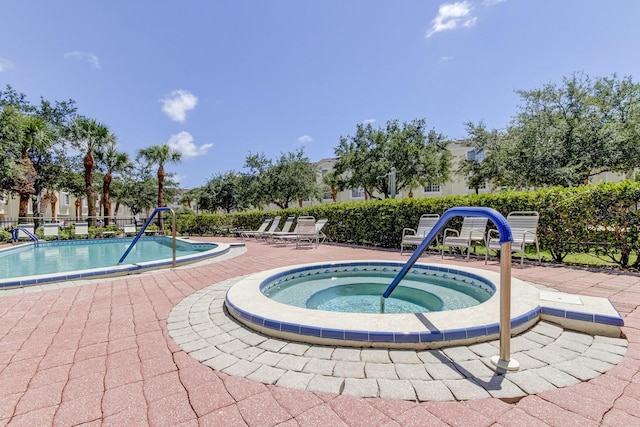 community pool featuring a patio area, a community hot tub, and fence