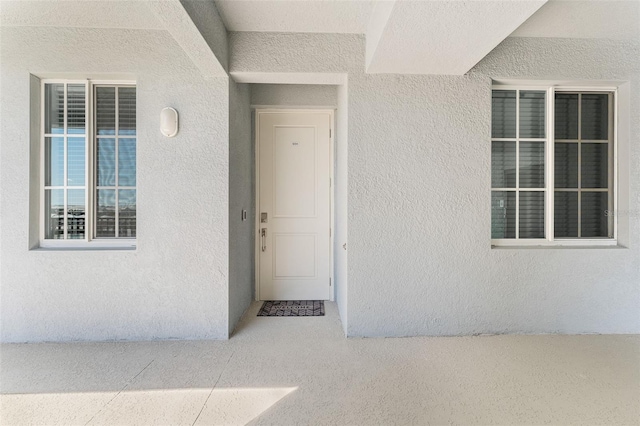 view of exterior entry with stucco siding