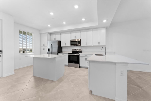 kitchen featuring recessed lighting, appliances with stainless steel finishes, a peninsula, and a sink