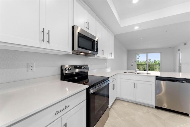 kitchen featuring white cabinetry, stainless steel appliances, light countertops, and a sink