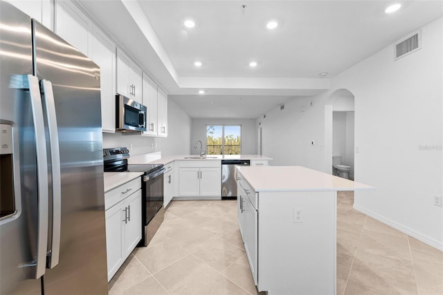 kitchen with light countertops, recessed lighting, appliances with stainless steel finishes, a peninsula, and a sink