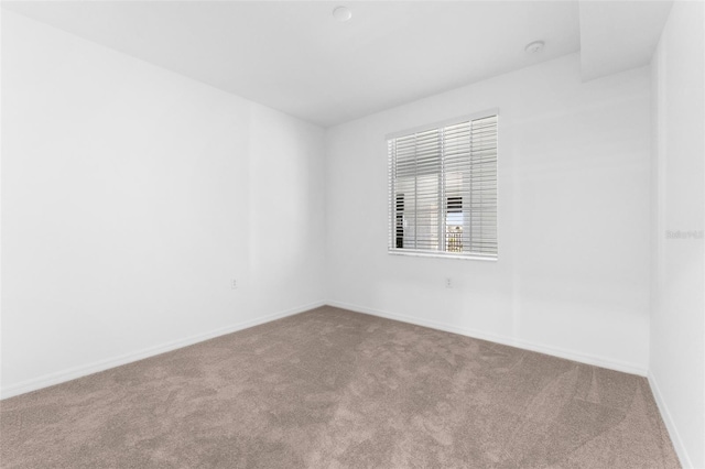 unfurnished room featuring baseboards and carpet