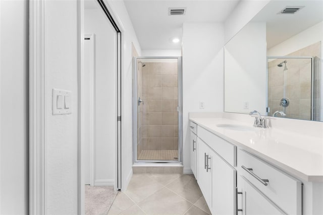 bathroom with tile patterned flooring, visible vents, a stall shower, and vanity