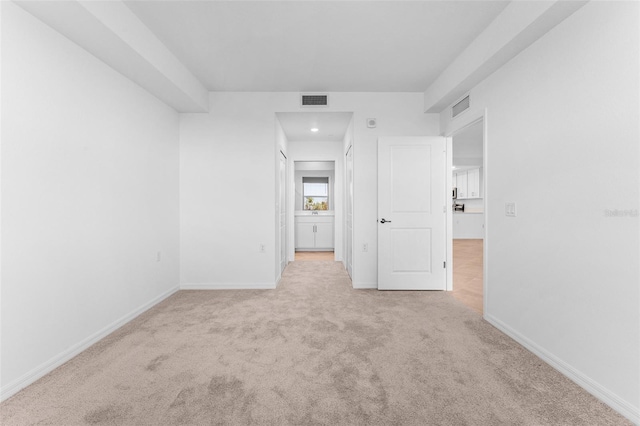 carpeted spare room featuring baseboards and visible vents