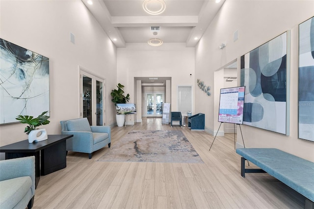 interior space with wood finished floors, visible vents, baseboards, a high ceiling, and beamed ceiling