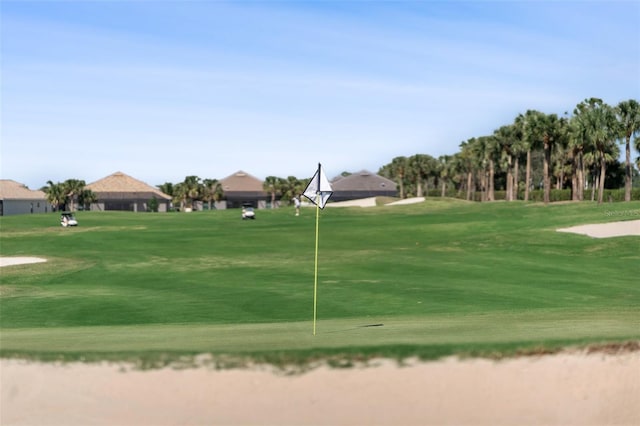 view of property's community with a lawn and view of golf course