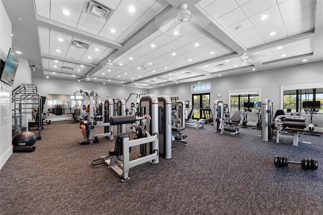 workout area featuring visible vents, a healthy amount of sunlight, and a high ceiling