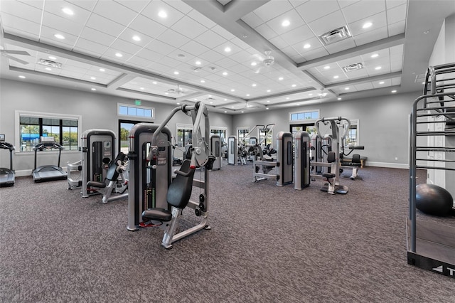 workout area with visible vents, baseboards, and a high ceiling