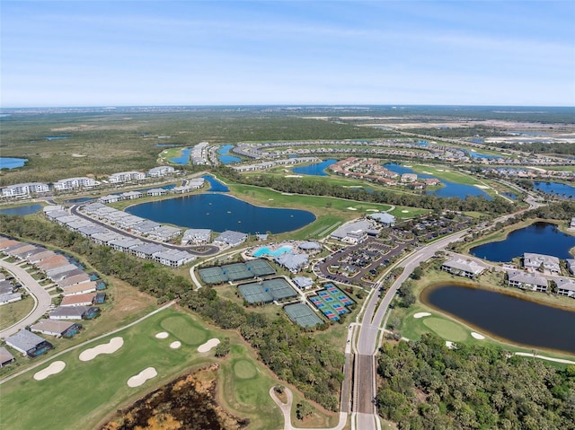 birds eye view of property with view of golf course and a water view