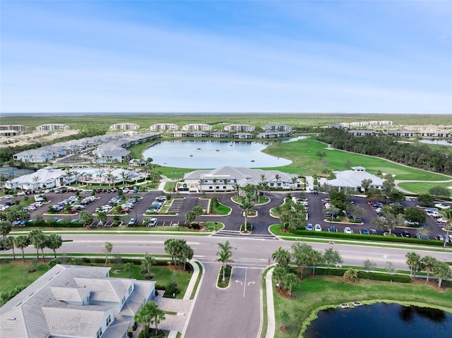 birds eye view of property with a water view and view of golf course