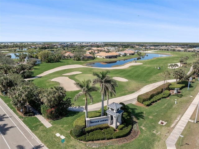 drone / aerial view with golf course view and a water view