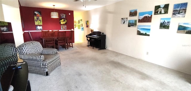 carpeted living room with a dry bar and ceiling fan