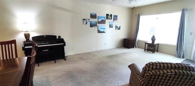 living area featuring carpet floors and a ceiling fan