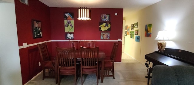 carpeted dining space with visible vents