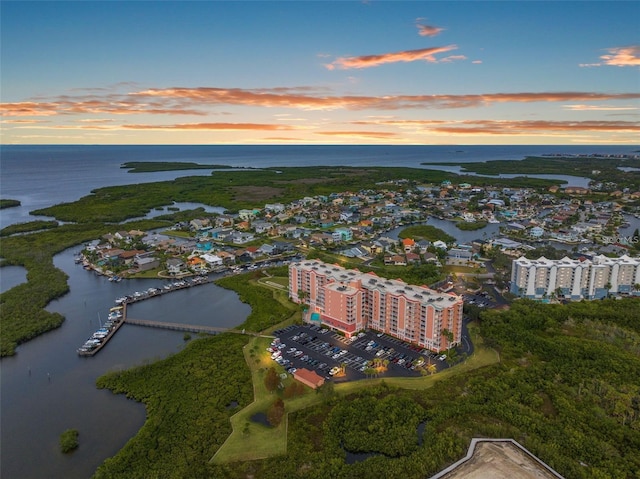 aerial view at dusk featuring a water view