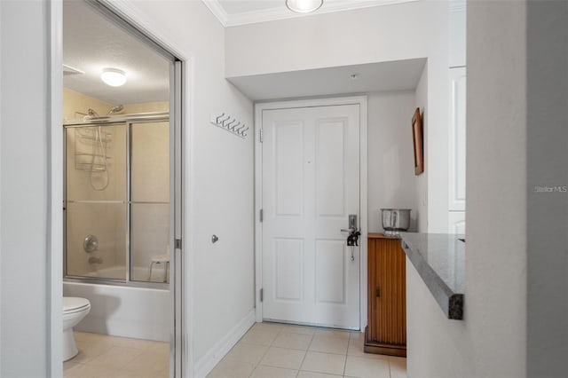 full bath featuring shower / bath combination with glass door, toilet, ornamental molding, baseboards, and tile patterned floors