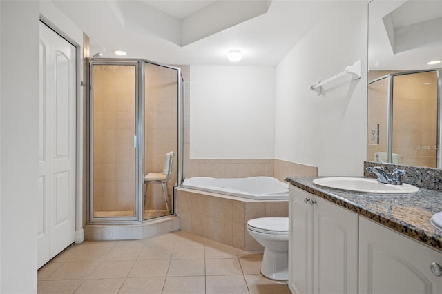 full bathroom featuring tile patterned floors, toilet, vanity, a shower stall, and a bath