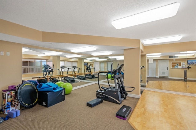 exercise room with visible vents and a textured ceiling