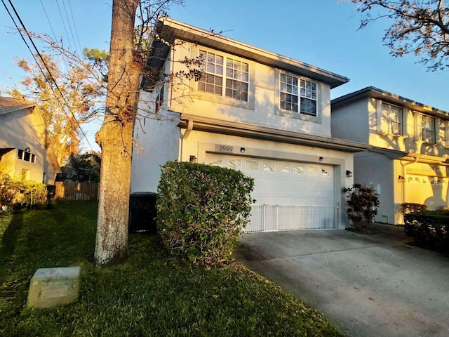 traditional-style house with a garage, concrete driveway, and stucco siding