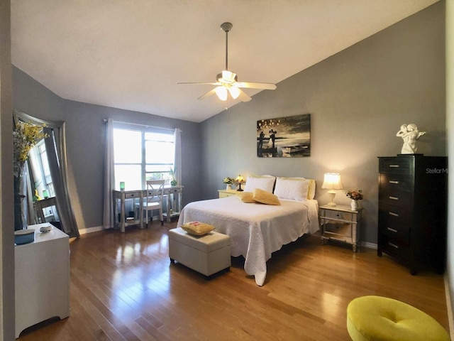 bedroom featuring a ceiling fan, lofted ceiling, baseboards, and wood finished floors