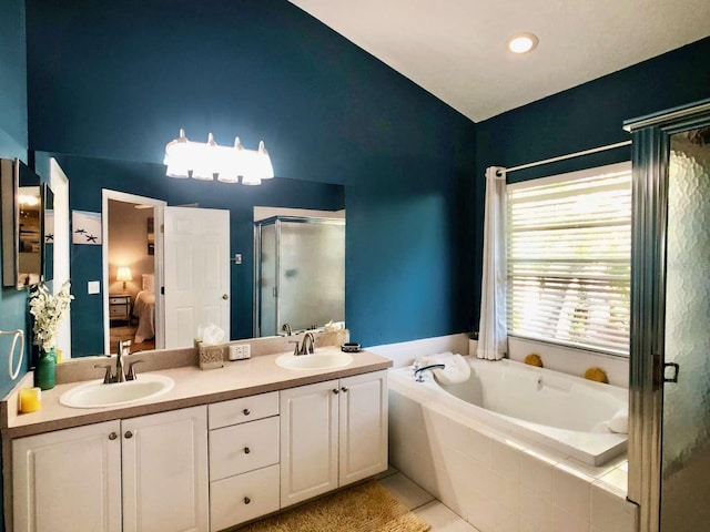 bathroom with a bath, a shower stall, a sink, and ensuite bathroom