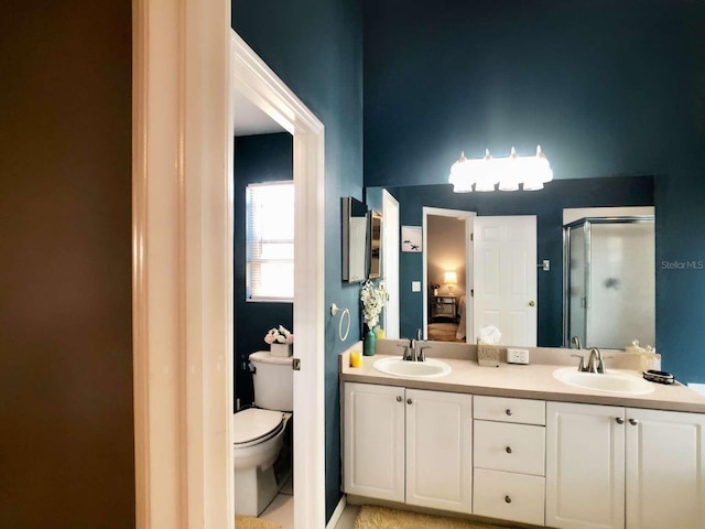 ensuite bathroom featuring toilet, a stall shower, a sink, and ensuite bathroom