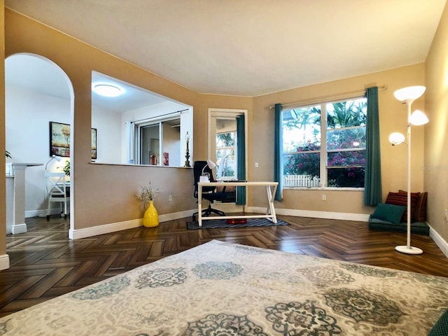 interior space featuring arched walkways and baseboards