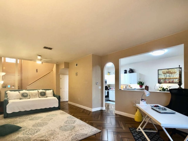 bedroom with baseboards, visible vents, and arched walkways